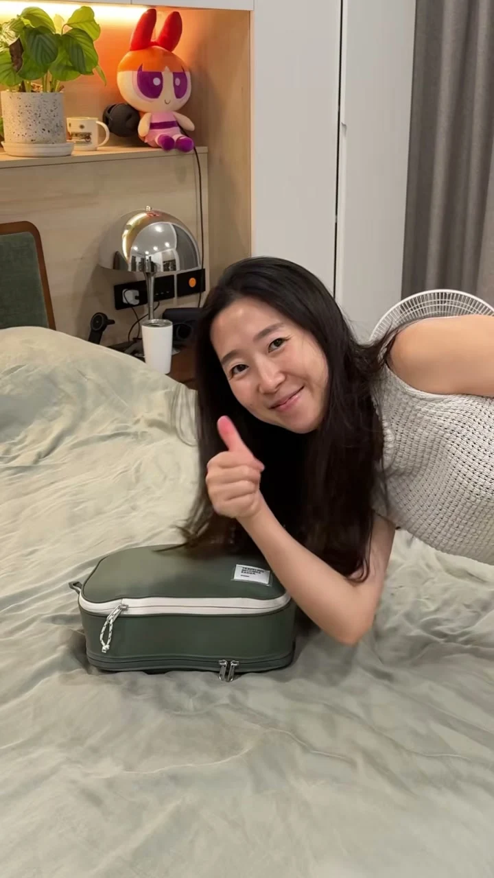 二代收納袋整理完成放在床上，秀秀在旁比讚