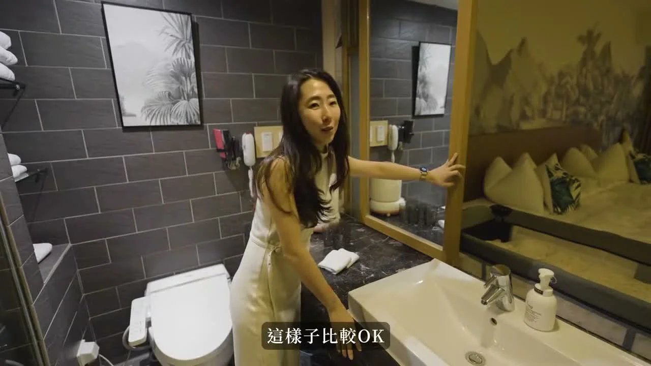 秀秀在凱撒房間的洗手台旁介紹衛浴與床區隔間