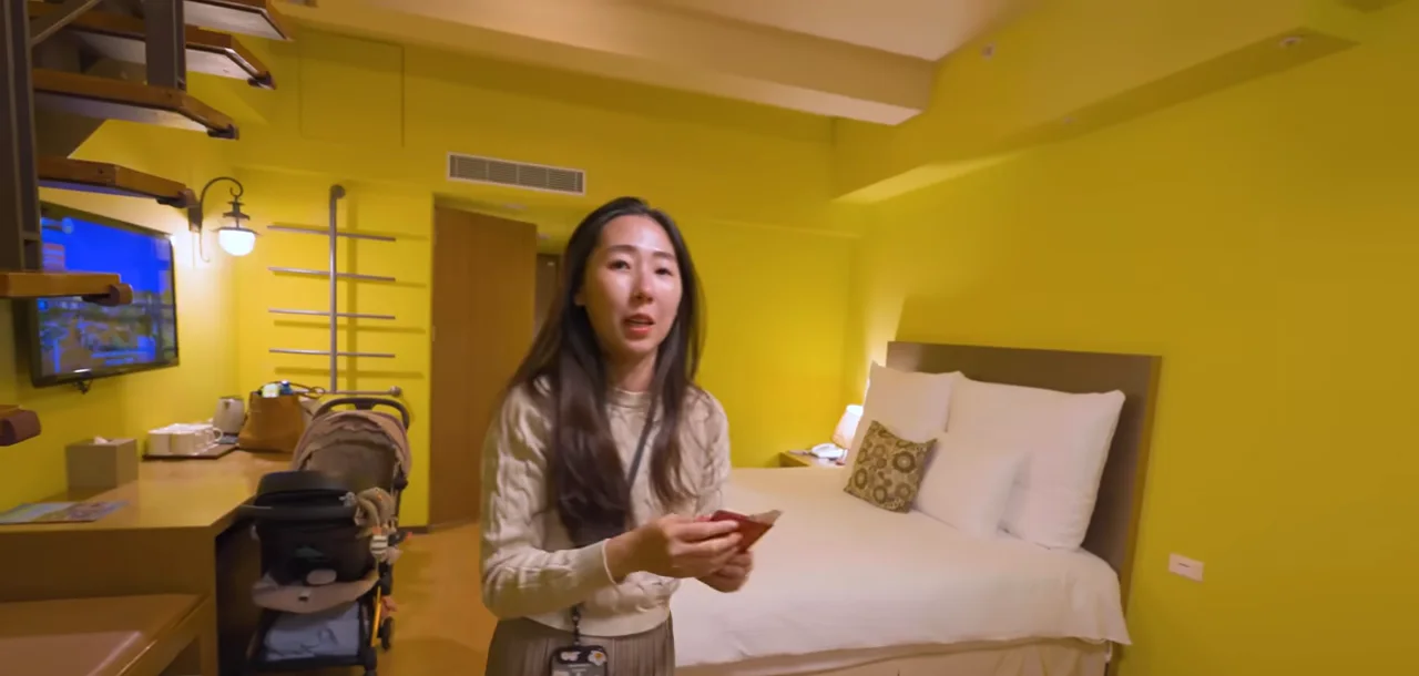 Queenie 在六福莊客房裡介紹床區與室內走道