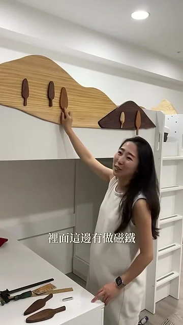 手指著床邊山形木擋上的小樹裝飾