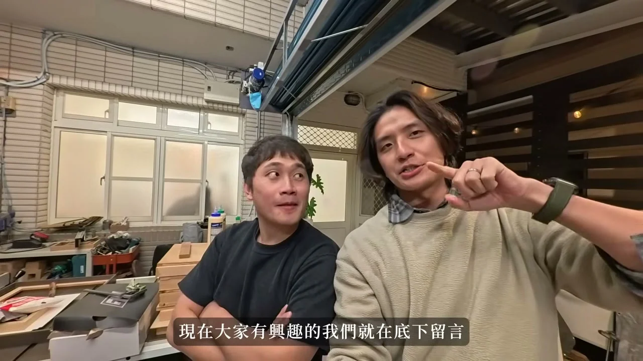 兩人在木工工作室交談，旁邊可見工作檯與工具