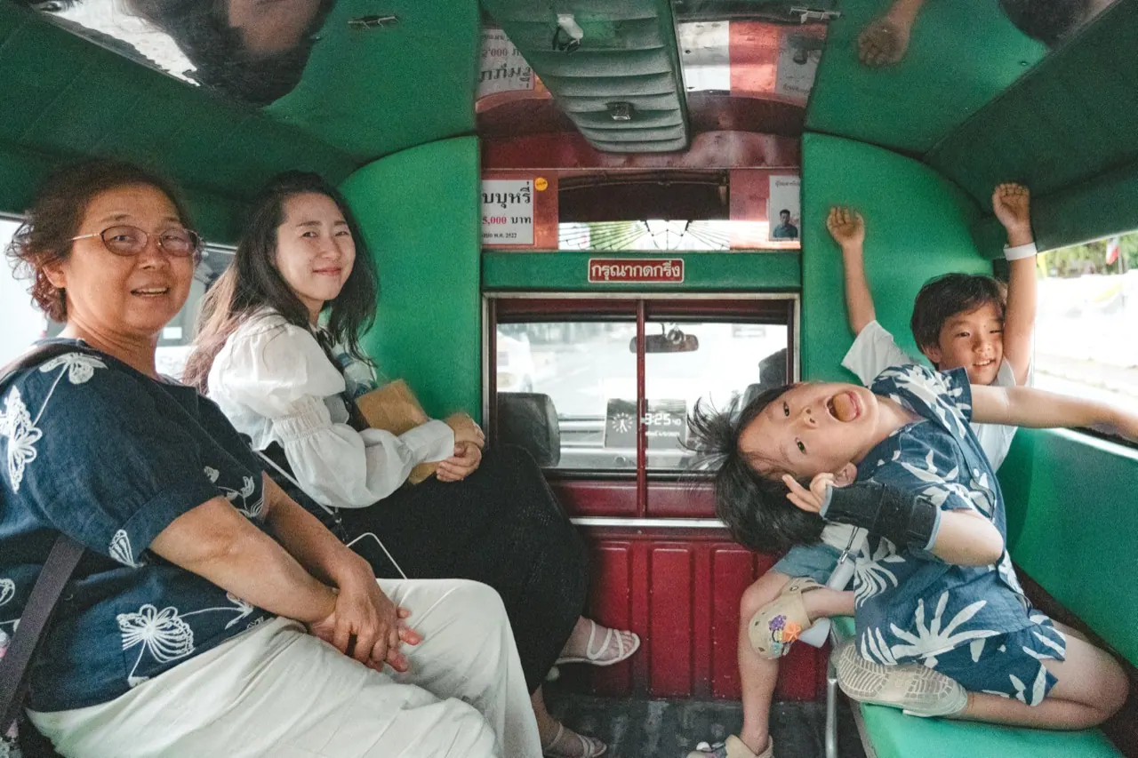 一家人坐在清邁雙條車的車廂裡