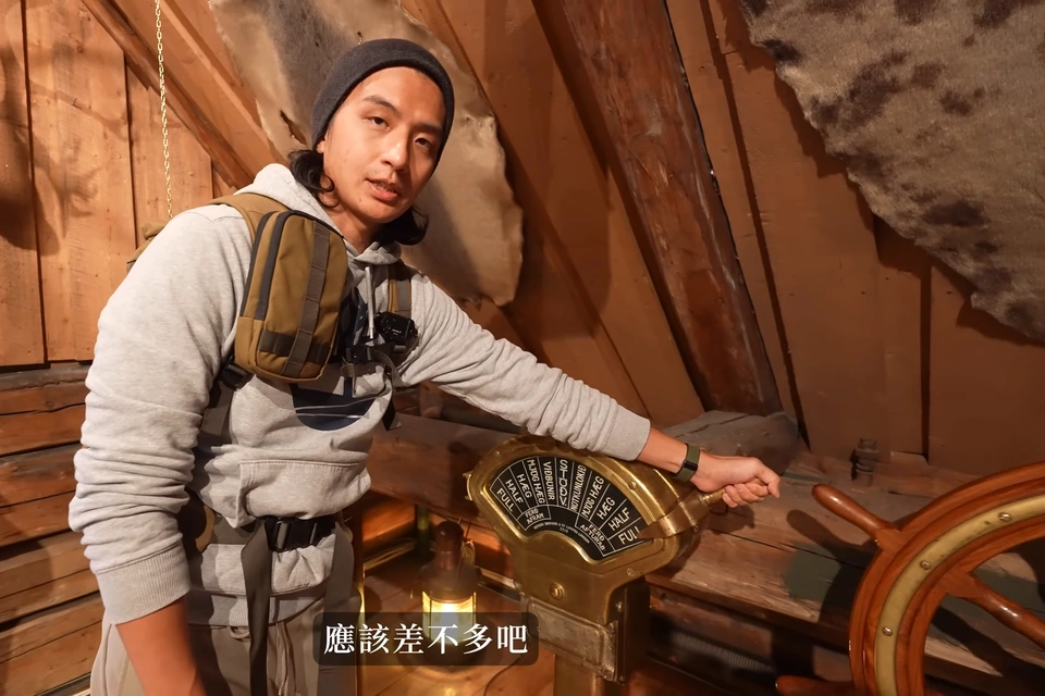 爸爸在極地博物館內握著船舵展示