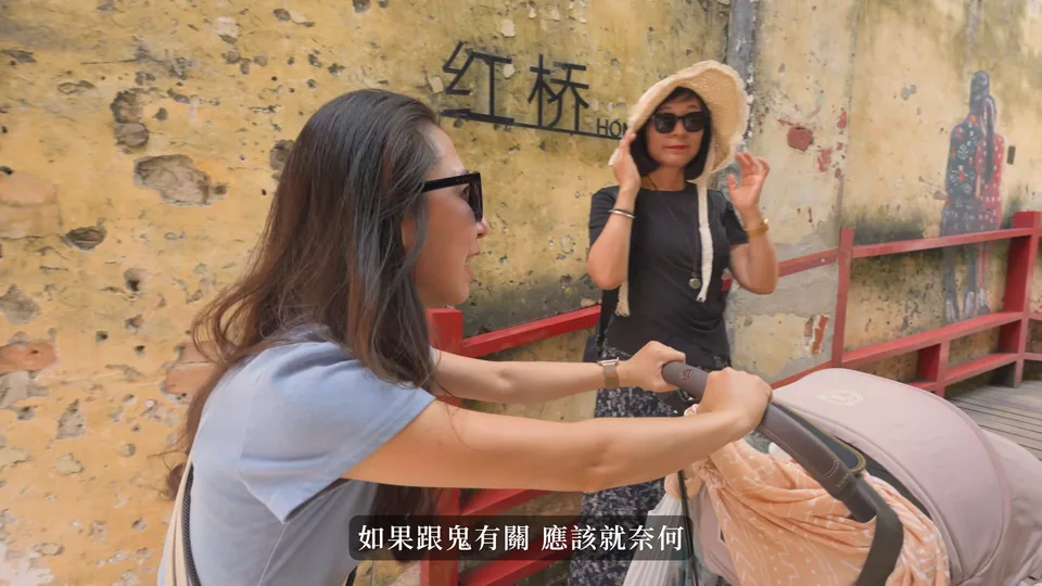 媽媽推著嬰兒車在壁畫牆旁