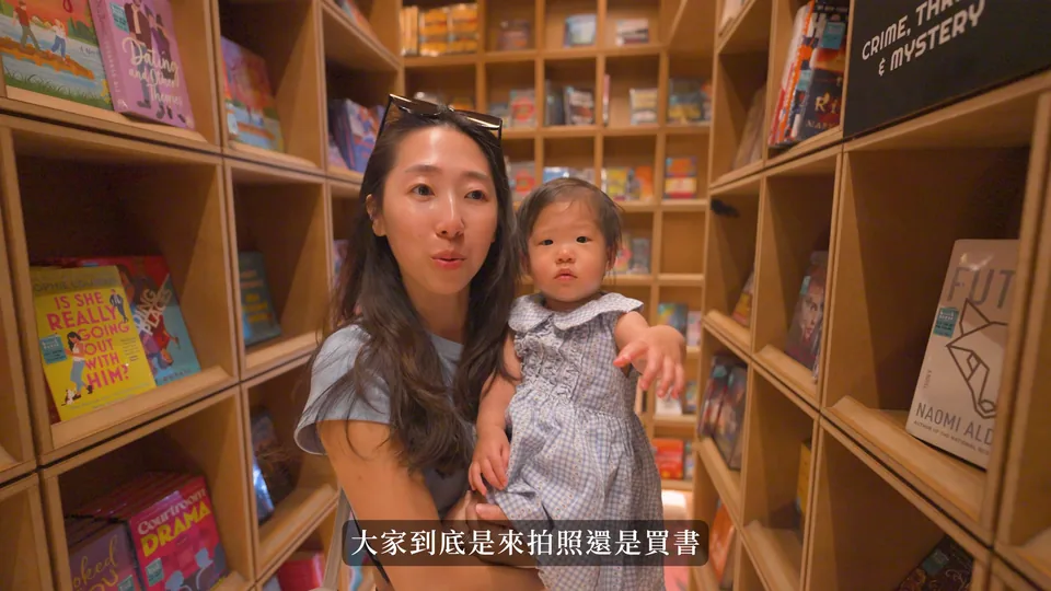 媽媽抱嬰兒在書架前