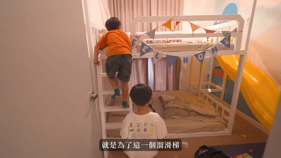 孩子在房內黃色溜滑梯上下舖旁