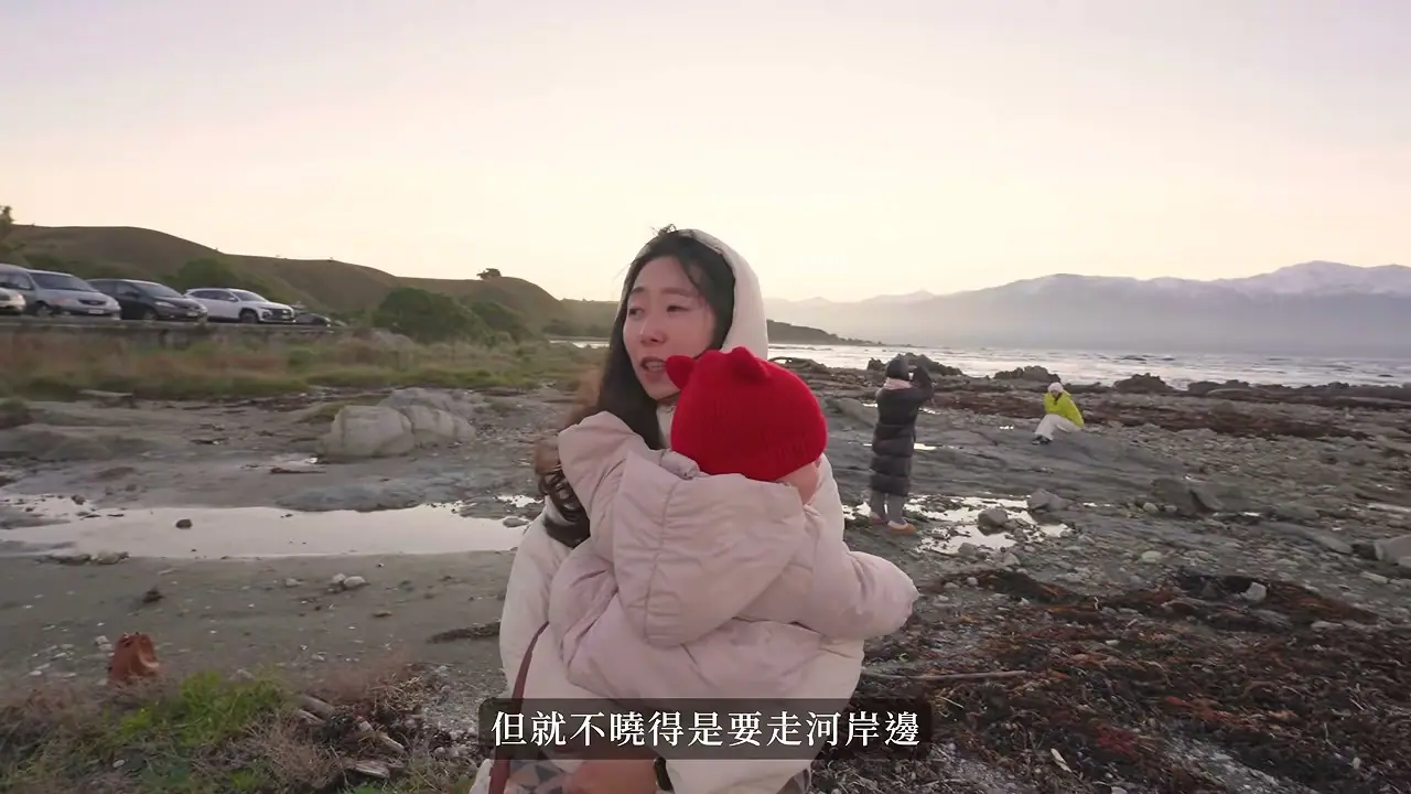 家人抱著孩子在 Kaikōura 岩岸散步