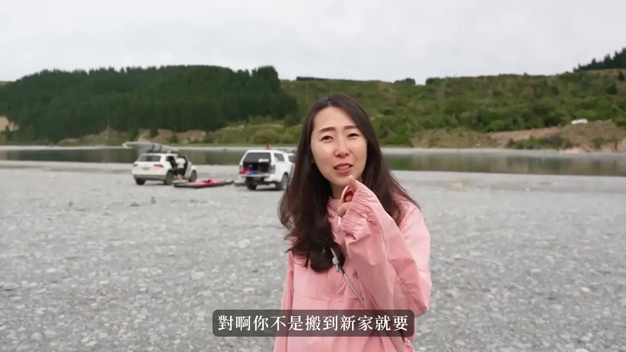 家人在 Rakaia Gorge 的碎石河岸說明行程,後方有車輛與水面