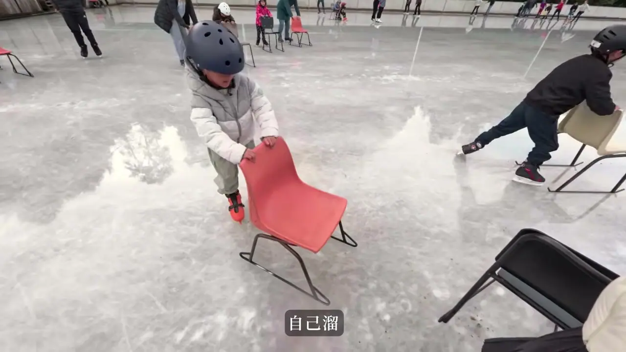 孩子戴安全帽,在 Staveley 冰面推著椅子練習滑冰