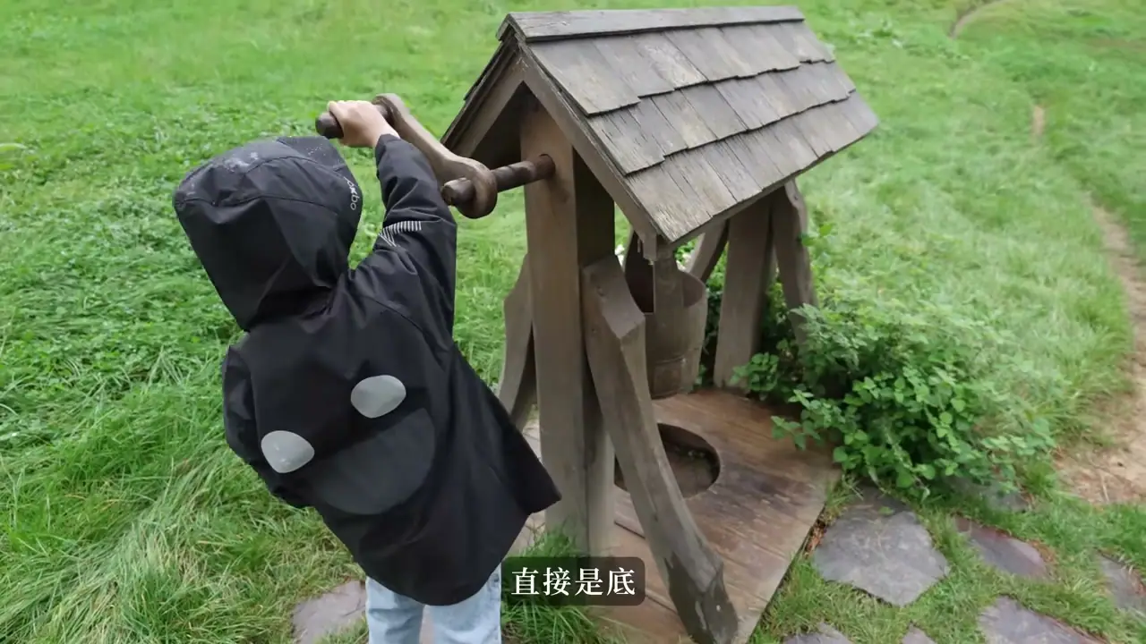 孩子在 Hobbiton 園區探看小水井