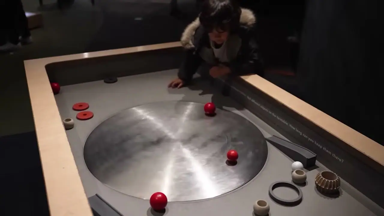 孩子在 Otago Museum 館內操作圓形旋轉互動展台