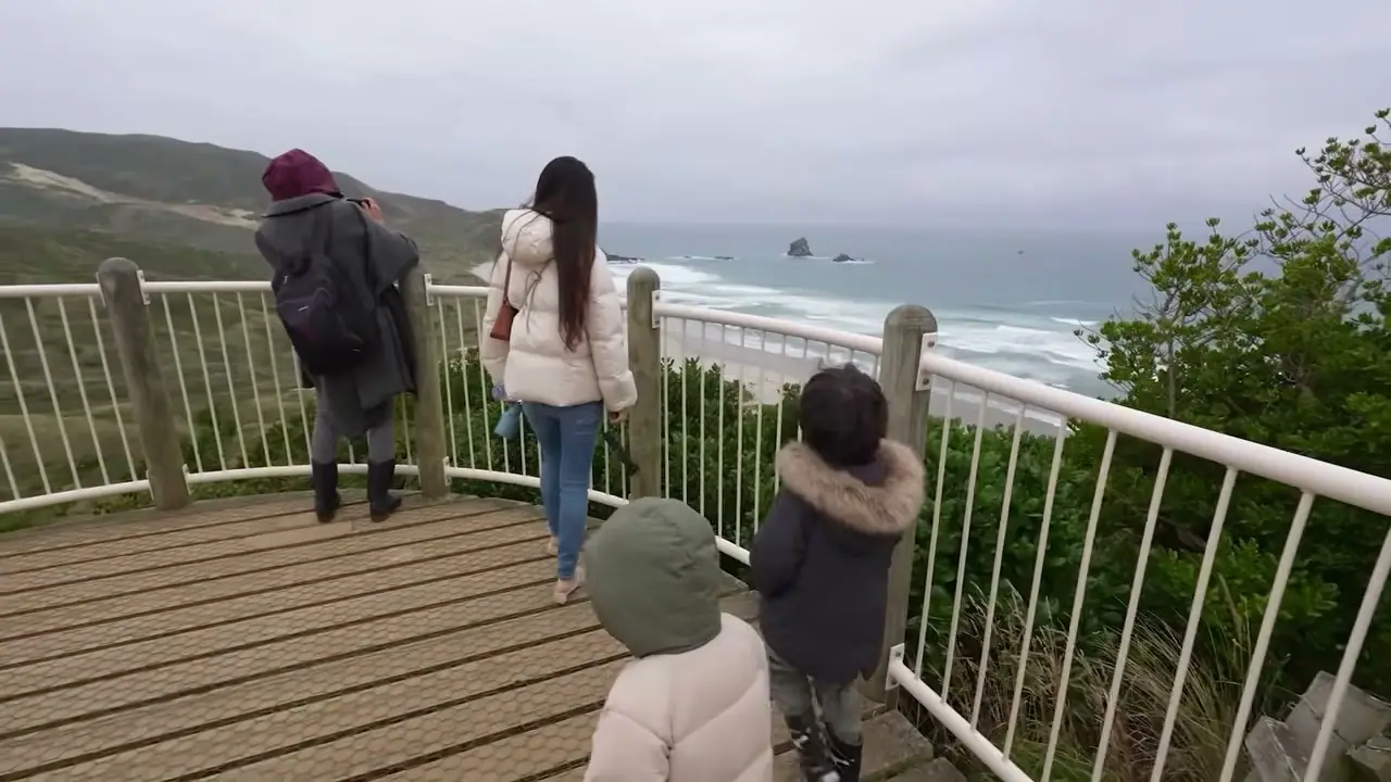 一家人在 Sandfly Bay 木平台眺望海灣