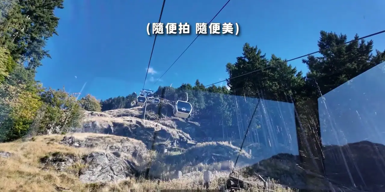 從纜車向前望見 Queenstown 的山坡、纜線與前方車廂