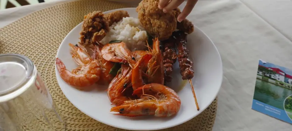 船上午餐餐盤近景,可見蝦、白飯、炸物與串物。