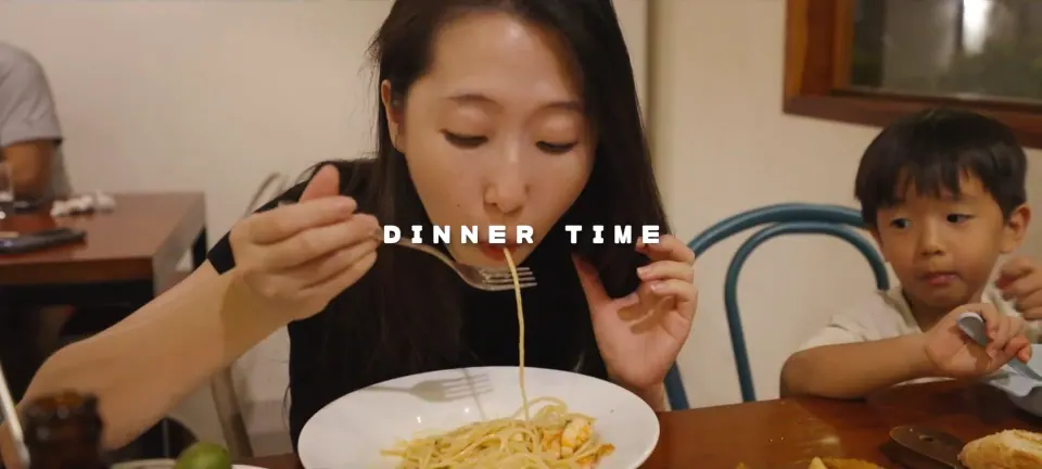 秀秀與孩子坐在 Ubeco 餐桌旁,秀秀正在吃麵。