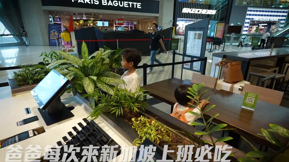 孩子與大人站在 Jewel Shake Shack 店面旁,後方可見 Shake Shack 招牌和櫃檯