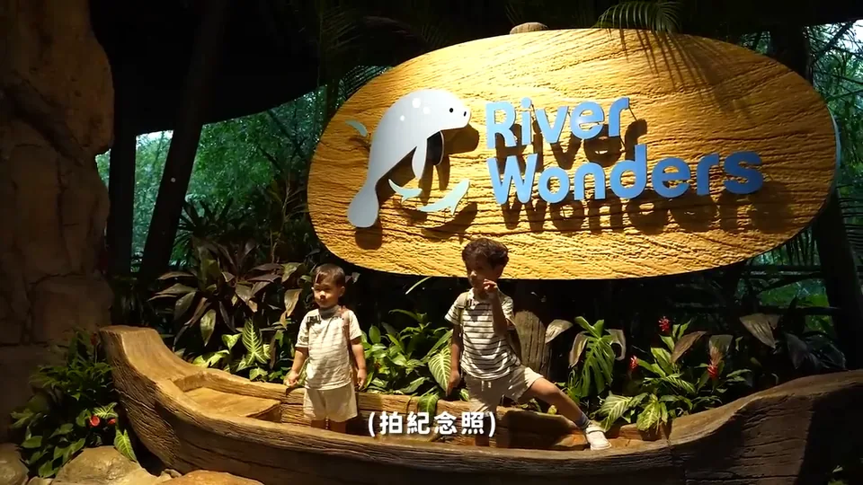 兩個哥哥在 River Wonders 招牌前的木舟造型布景裡合照。