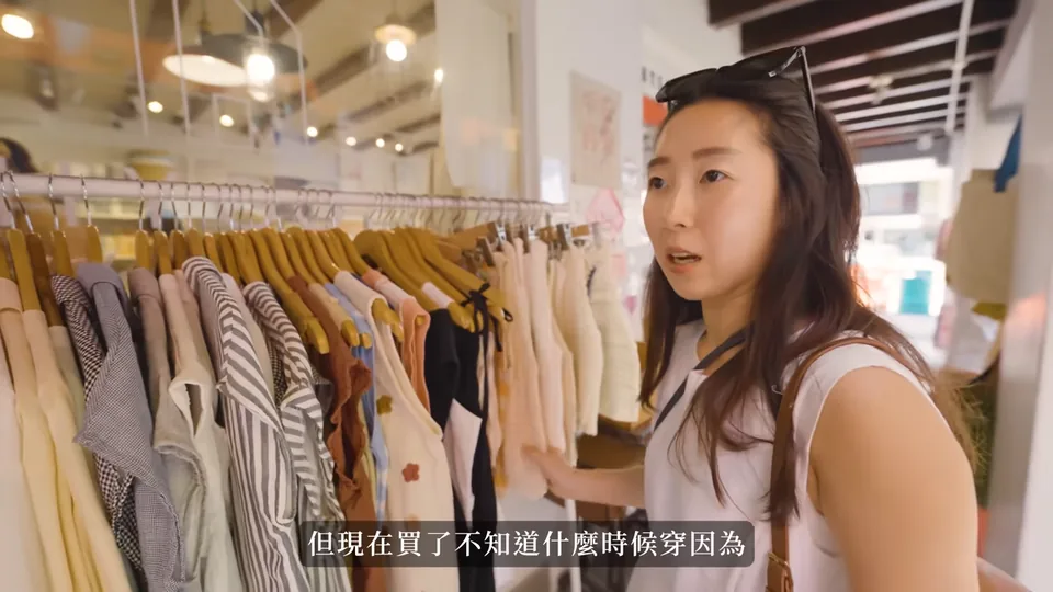 秀秀站在哈芝巷的服飾店裡,身旁的衣架掛著上衣。
