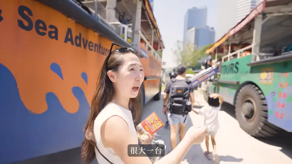 秀秀站在橘色 Sea Adventure 水陸車旁,另一側停著綠色車輛。