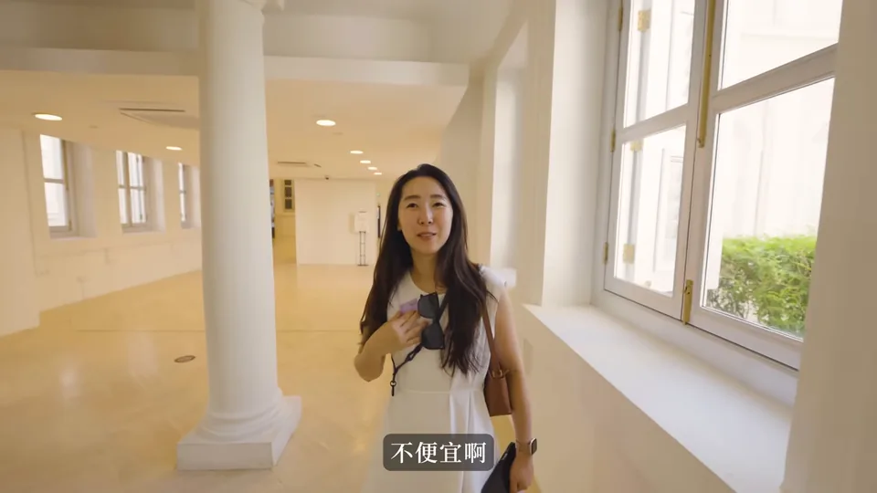 秀秀站在新加坡國家博物館的明亮走廊,旁邊有白色柱子與大窗戶。